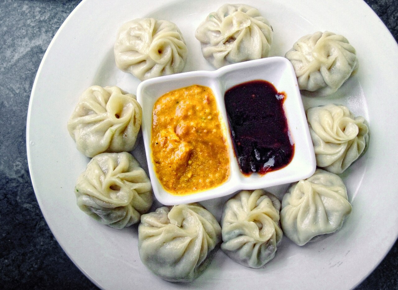A plate of steamed momo dumplings served with tomato achar in Nepal