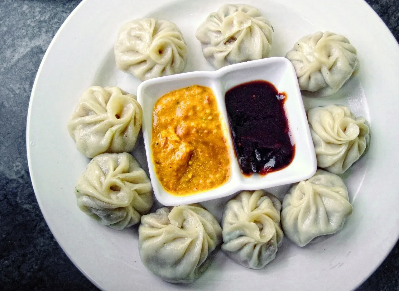 A plate of steamed momo dumplings served with tomato achar in Nepal