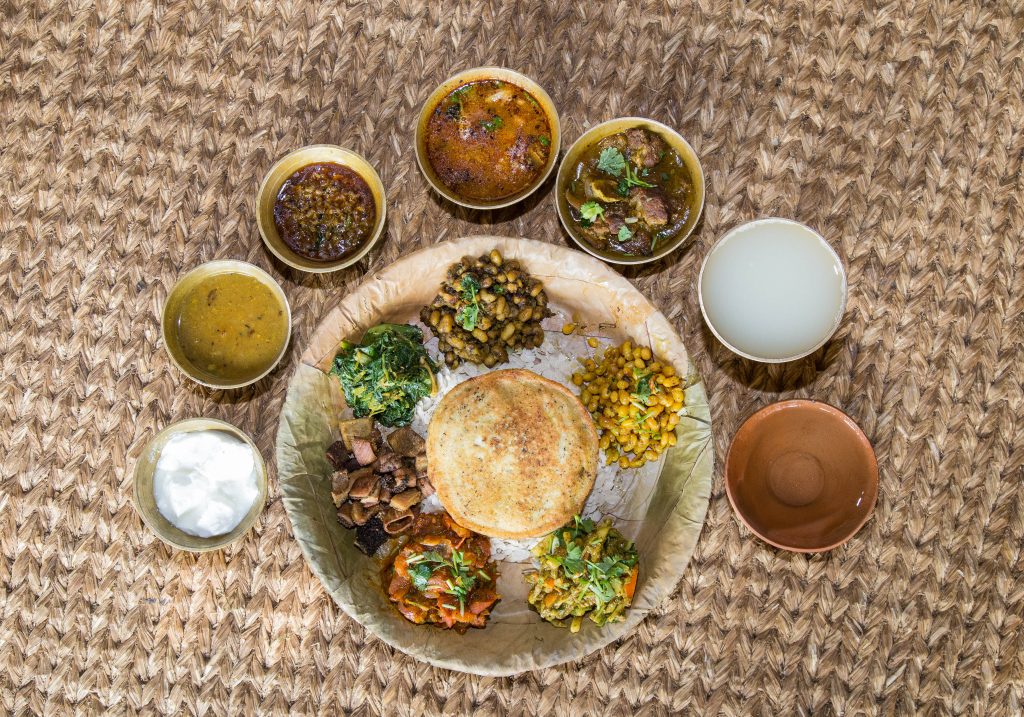 Traditional Newari Bhoye feast with multiple dishes served on leaf plates