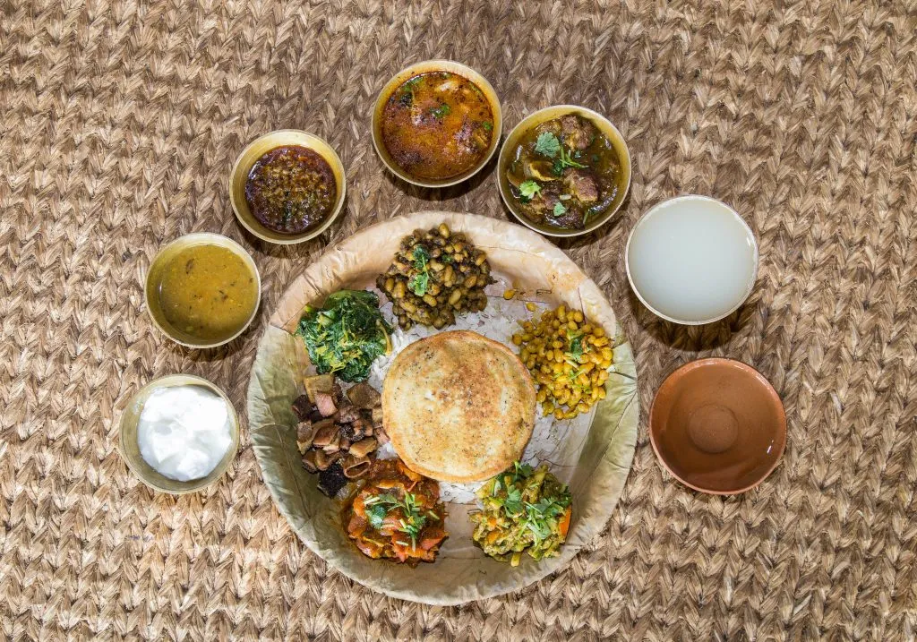 Traditional Newari Bhoye feast with multiple dishes served on leaf plates