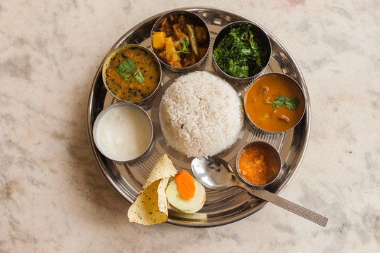 Traditional Thakali Khana set with rice, dal, curries, and pickles on a brass platter